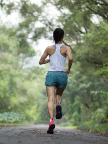 A woman running outside training for her first marathon.