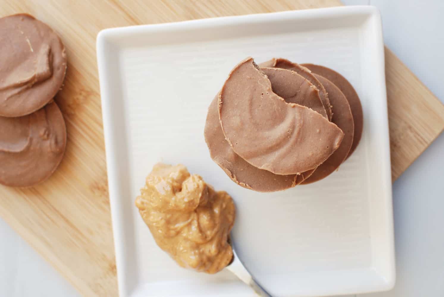 Overhead shot of peanut butter protein fudge bites on a white plate.