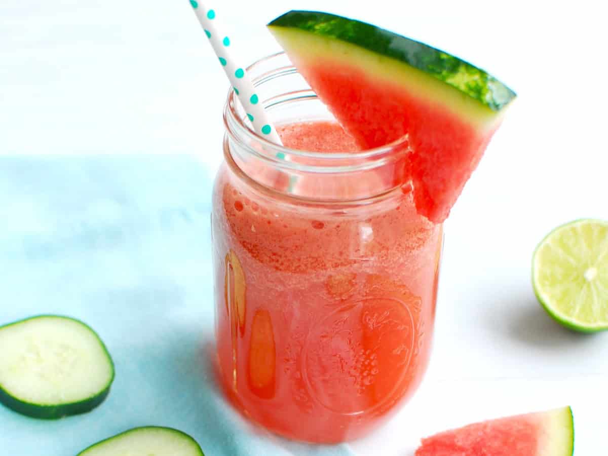 A watermelon cucumber smoothie garnished with a slice of watermelon.