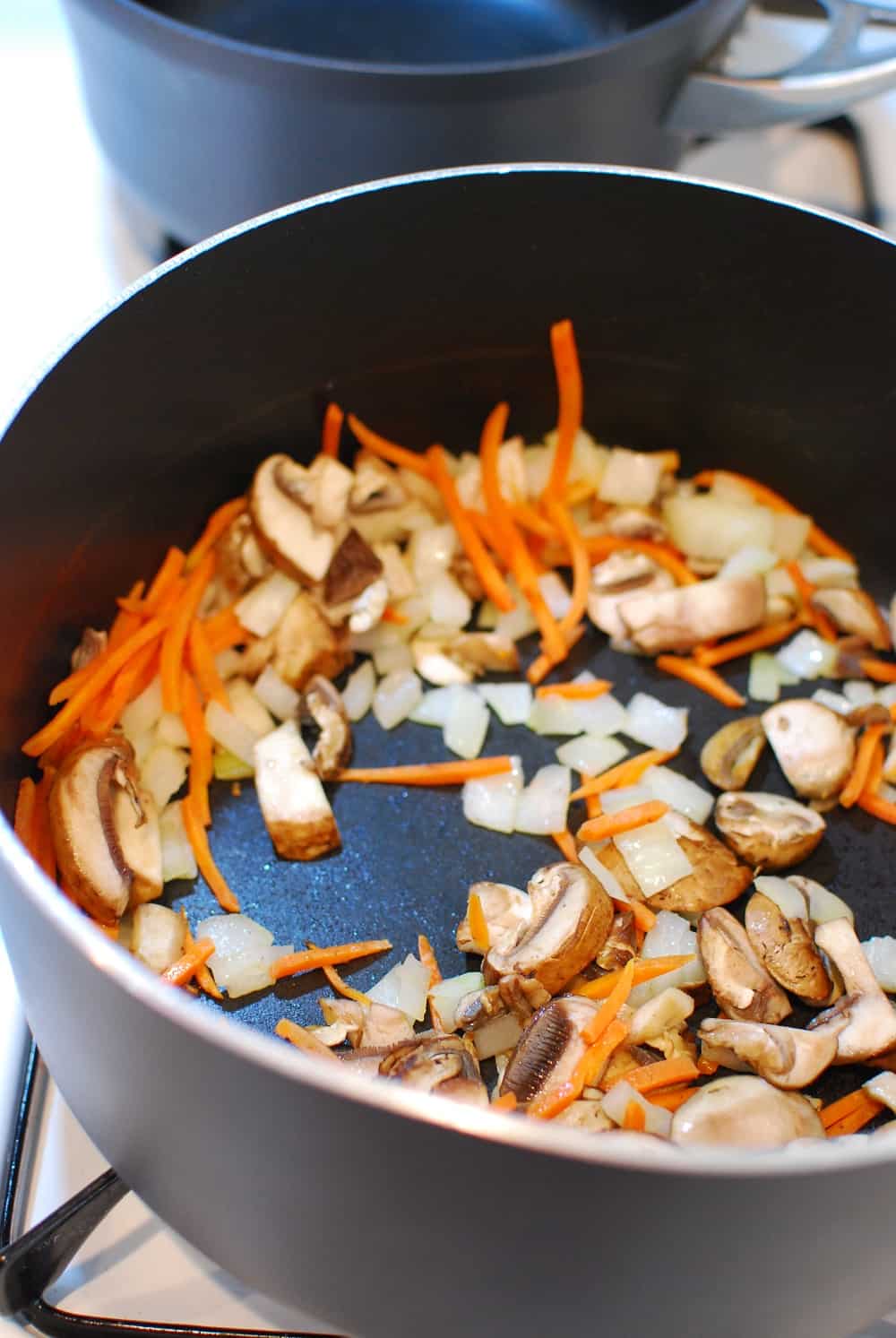 Carrots, onions, and mushrooms in a pot