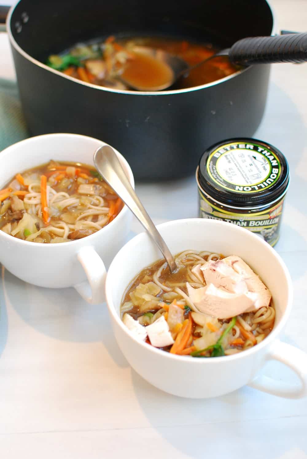 Soba noodle broth bowl in a soup mug topped with sliced chicken