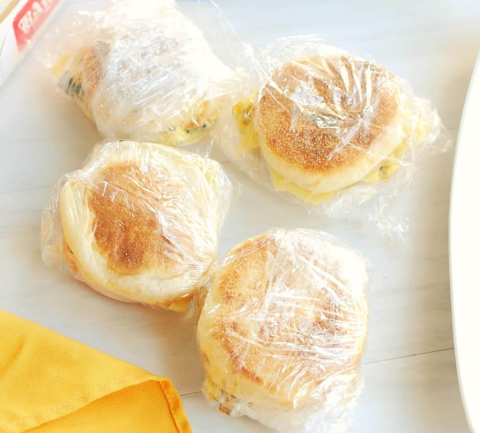 Vegetarian breakfast sandwiches wrapped in plastic wrap to get ready to freeze.