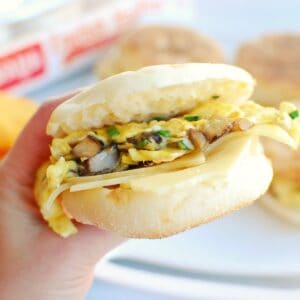 A woman's hand holding a vegetarian meal prep breakfast sandwich.