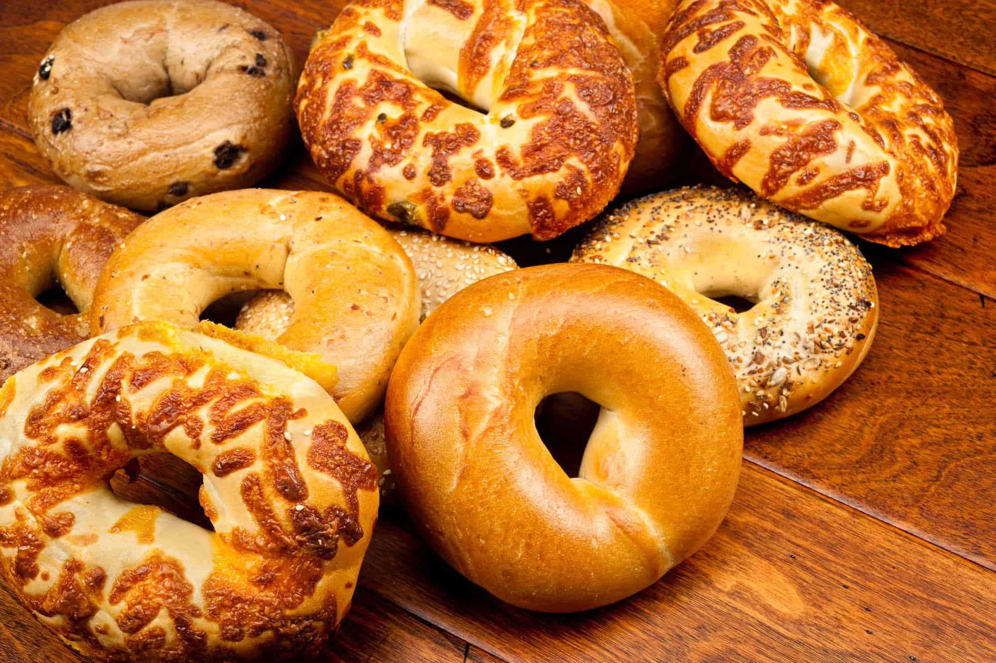 An assortment of fresh bagels on a wooden table