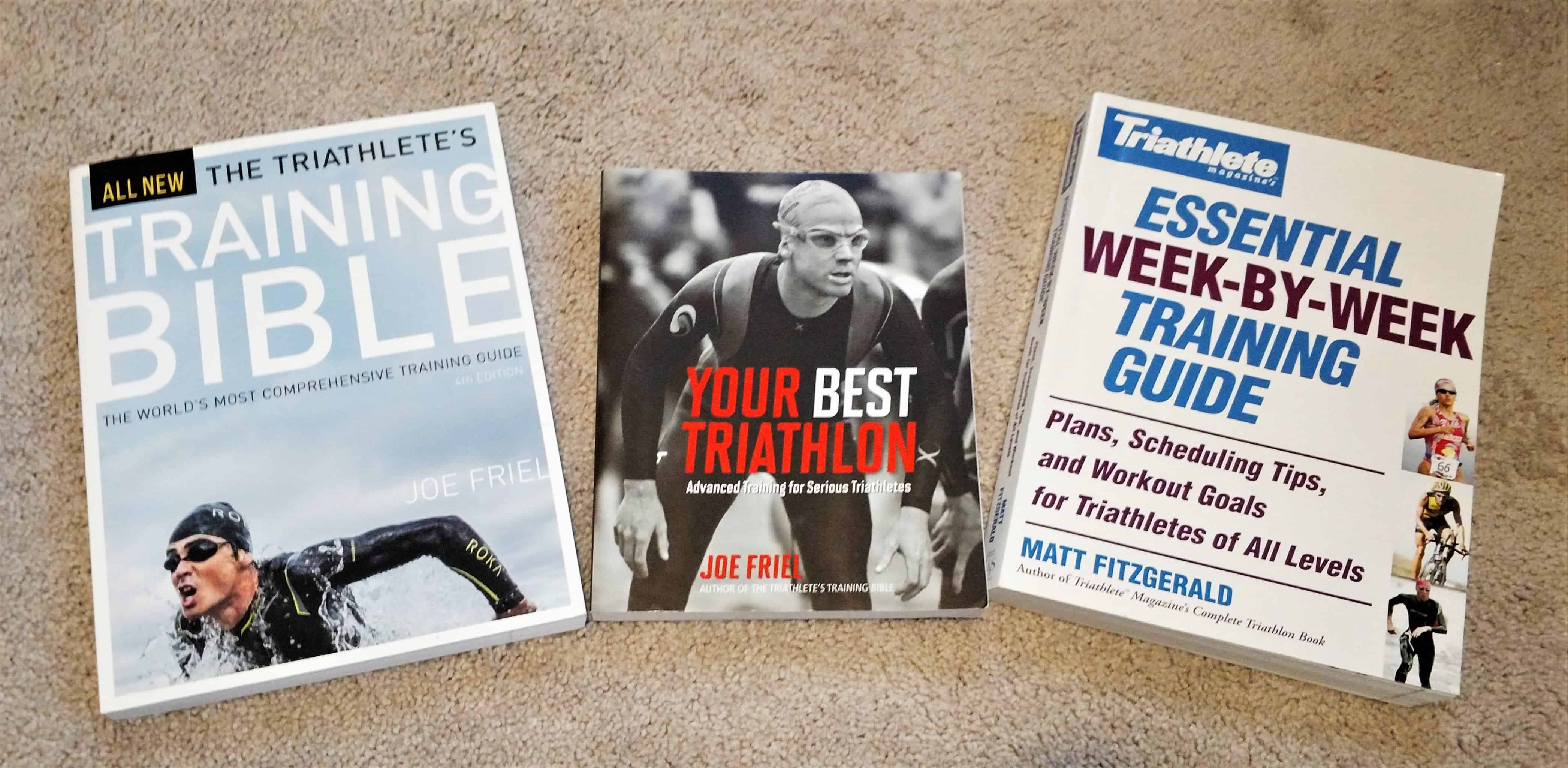 Three triathlon training books on the floor.