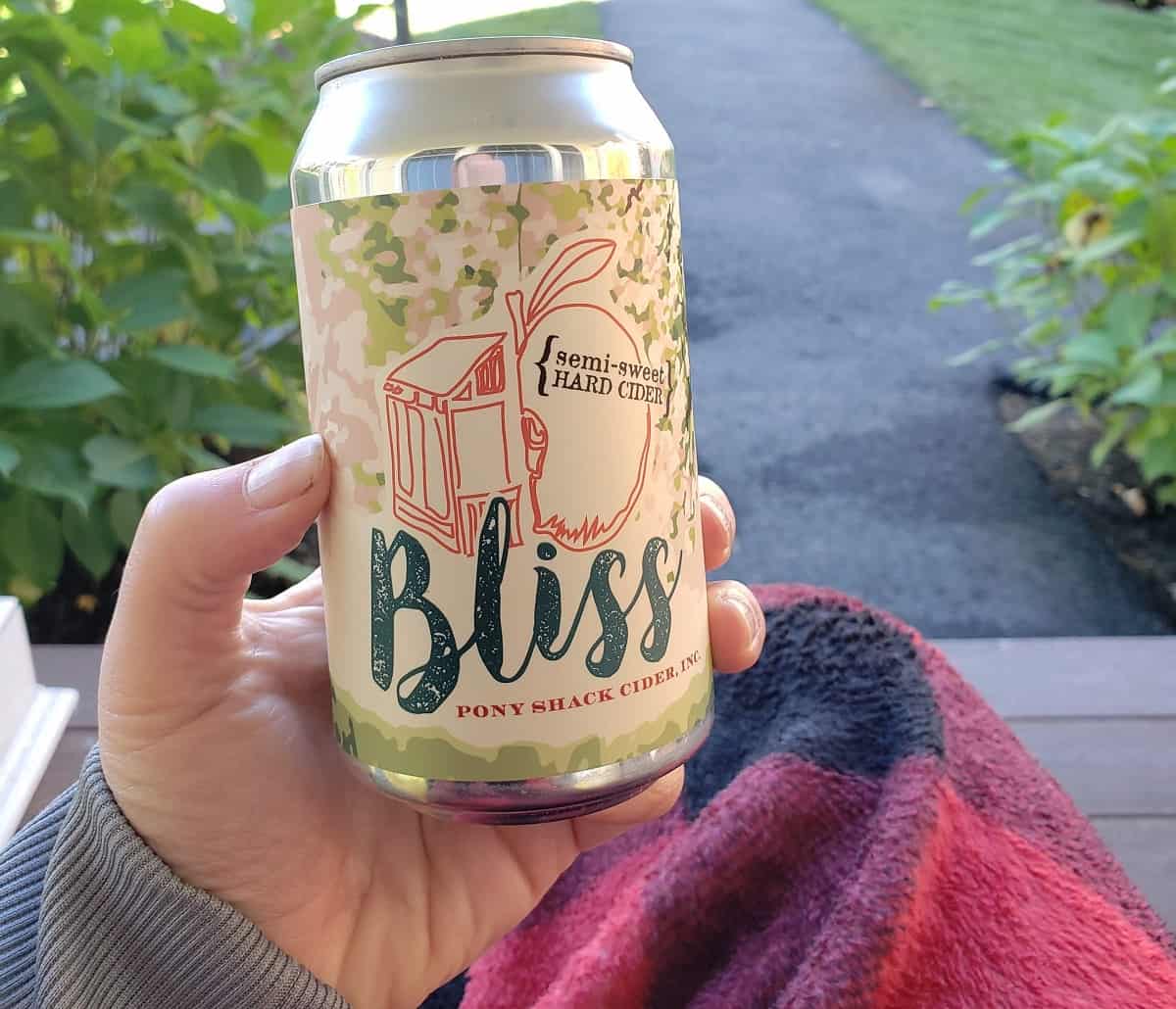 A can of hard cider in a woman's hand.