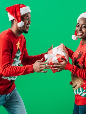 A woman giving a man a wrapped food gift.