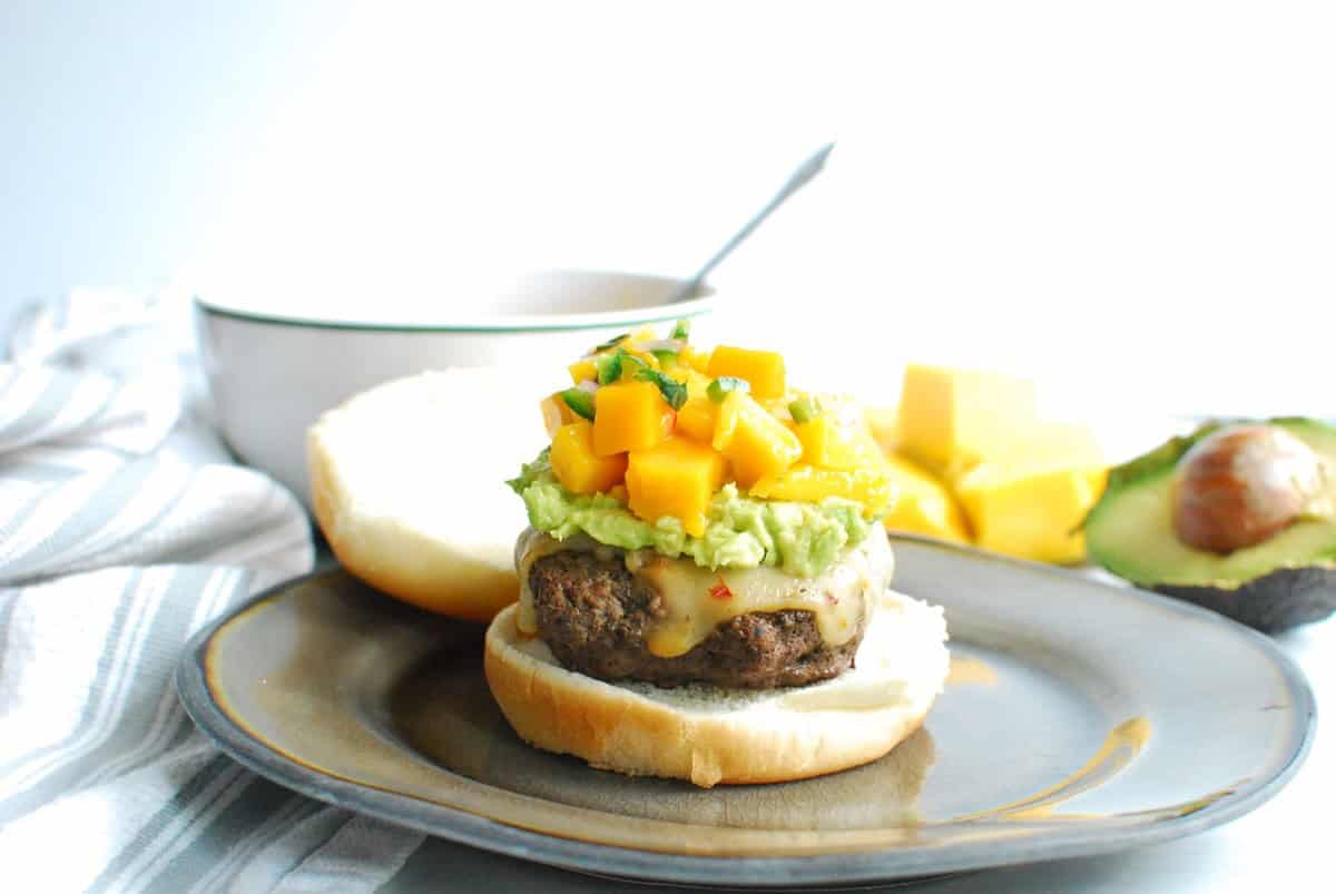 A burger just topped with mano salsa.