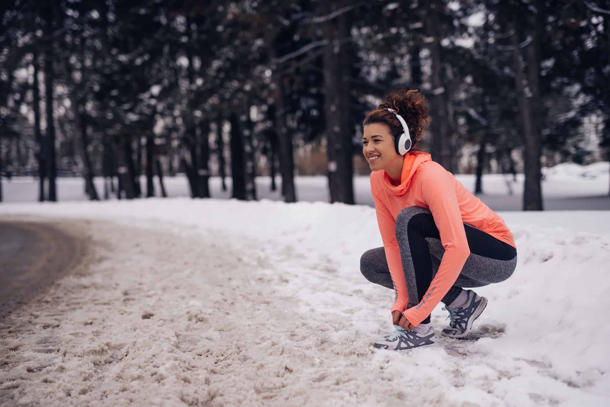 A woman tying her shoes getting ready to run