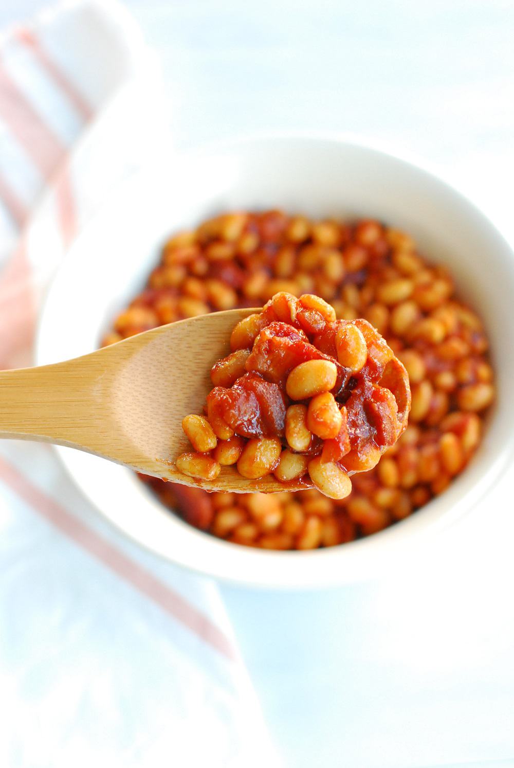 Wooden spoon full of easy healthy baked beans
