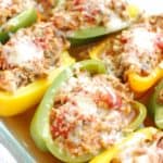 A casserole dish with cooked chicken stuffed peppers