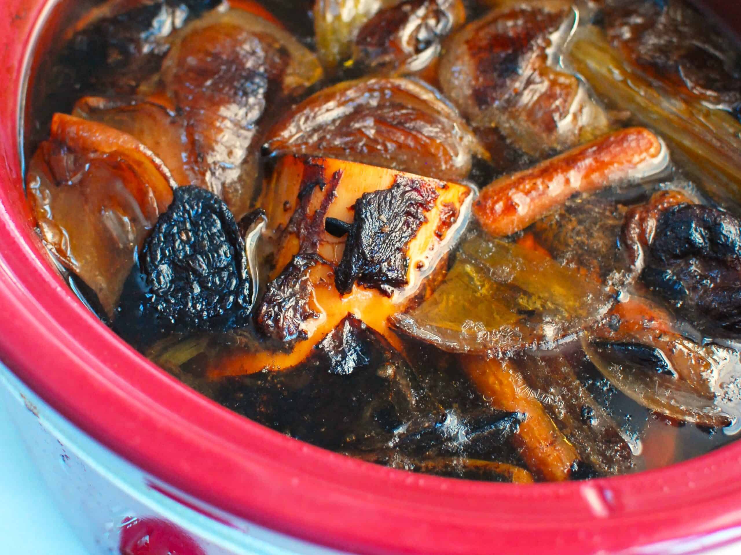 A slow cooker with homemade bone broth before being strained.