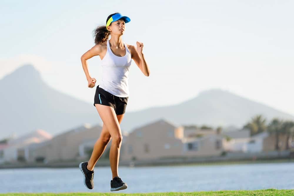 a woman running outside on grass