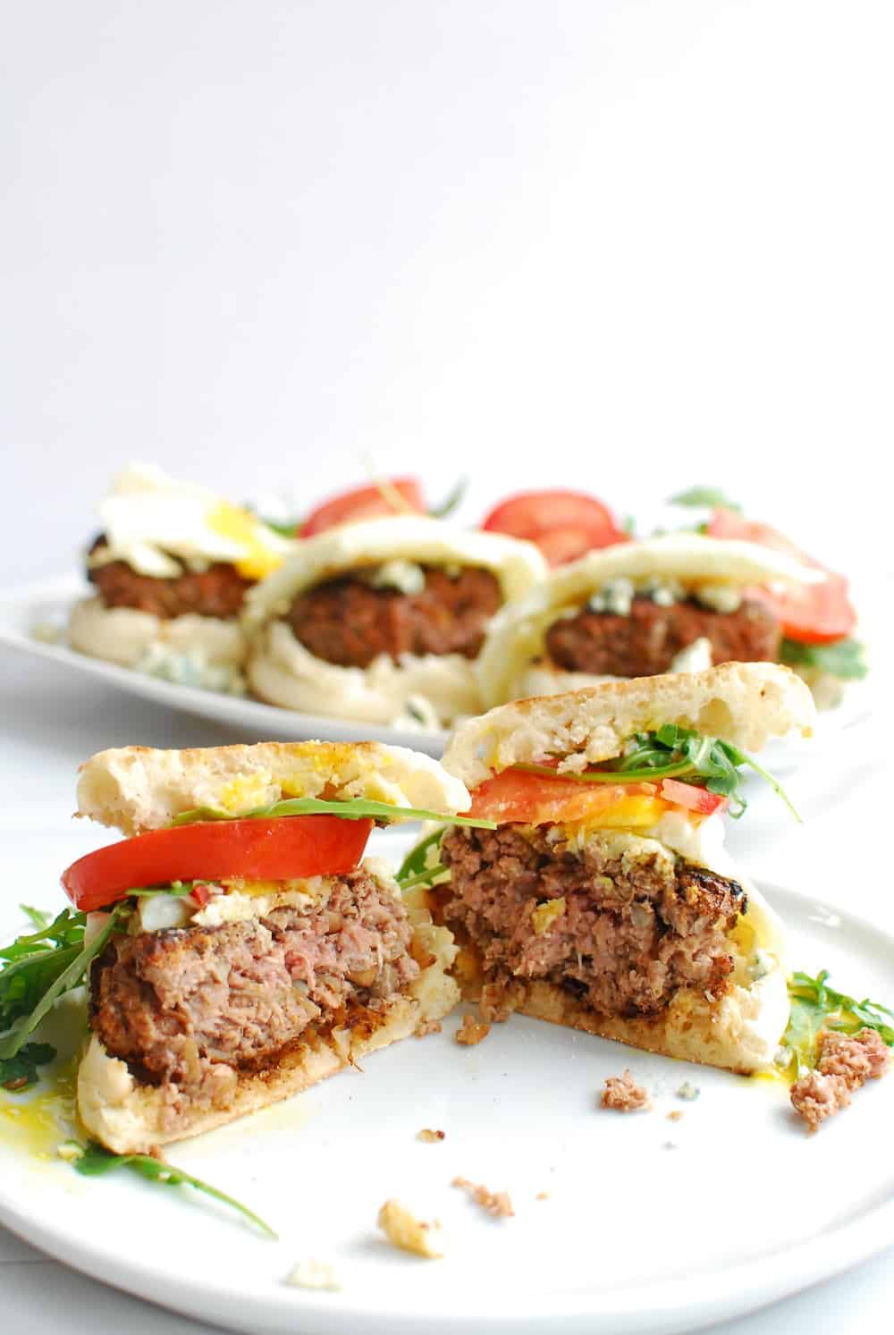 A black and blue burger cut in half on a white plate