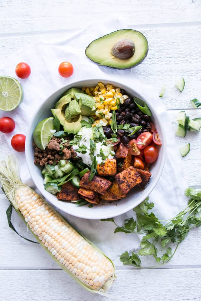 Sweet Potato Taco Bowl on a table beside avocado.