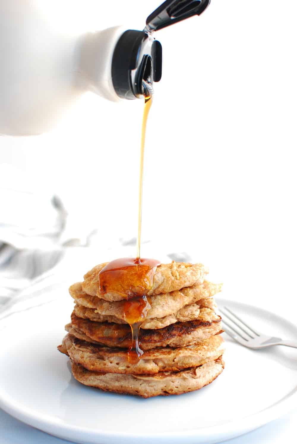 A stack of low calorie pancakes with maple syrup drizzled on top.