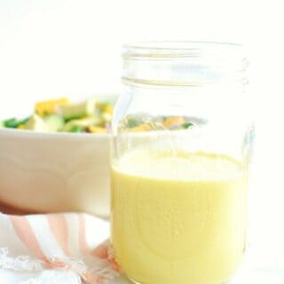 A mason jar half full of mango salad dressing