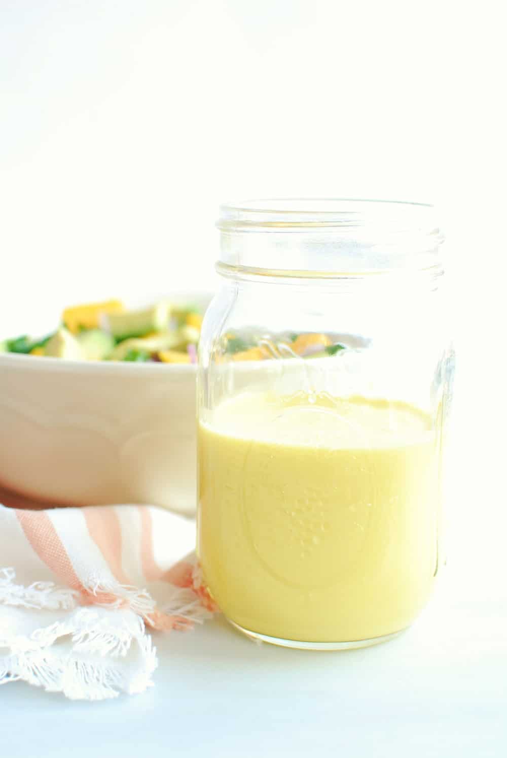 A mason jar half full of mango salad dressing