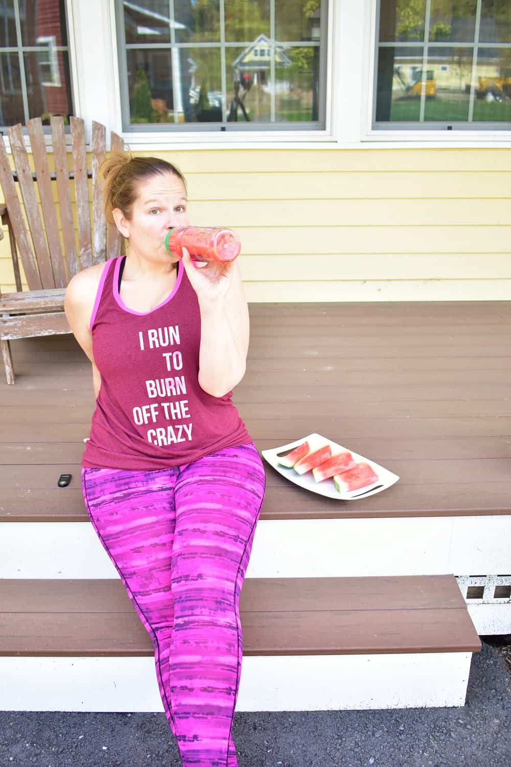 A woman drinking watermelon juice before a workout.
