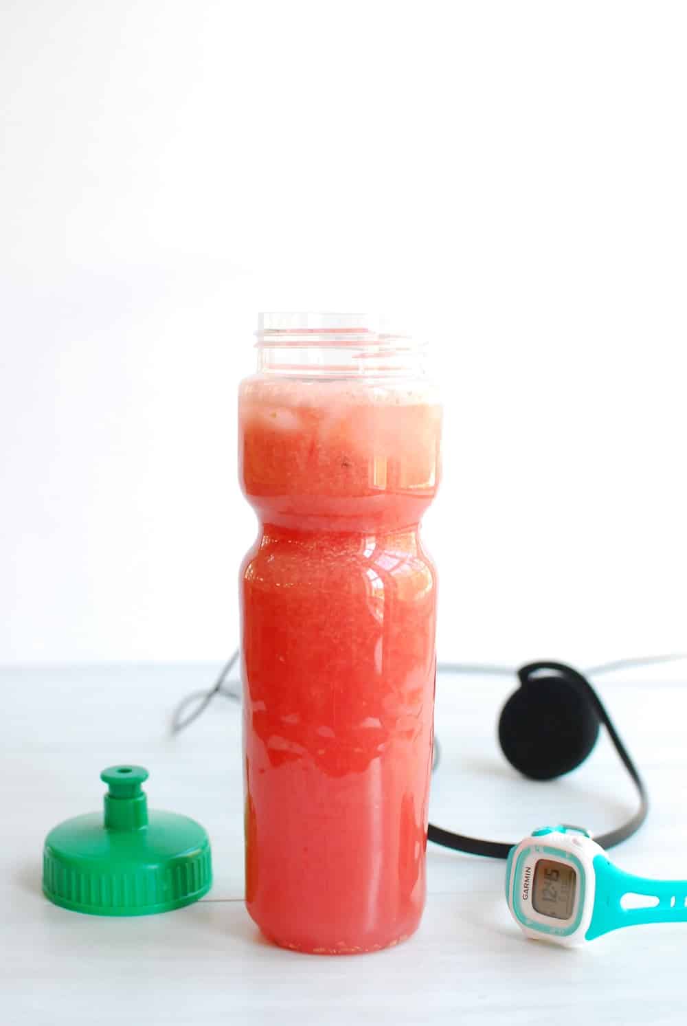 A sports drink bottle filled with a natural watermelon electrolyte drink