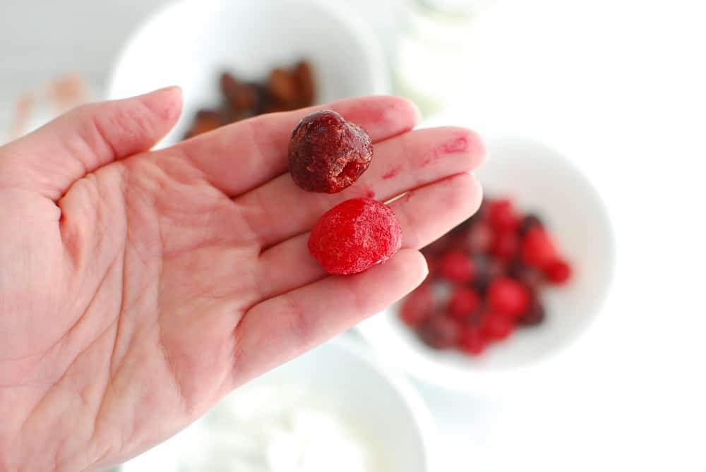 A woman's hand holding sweet and tart cherries