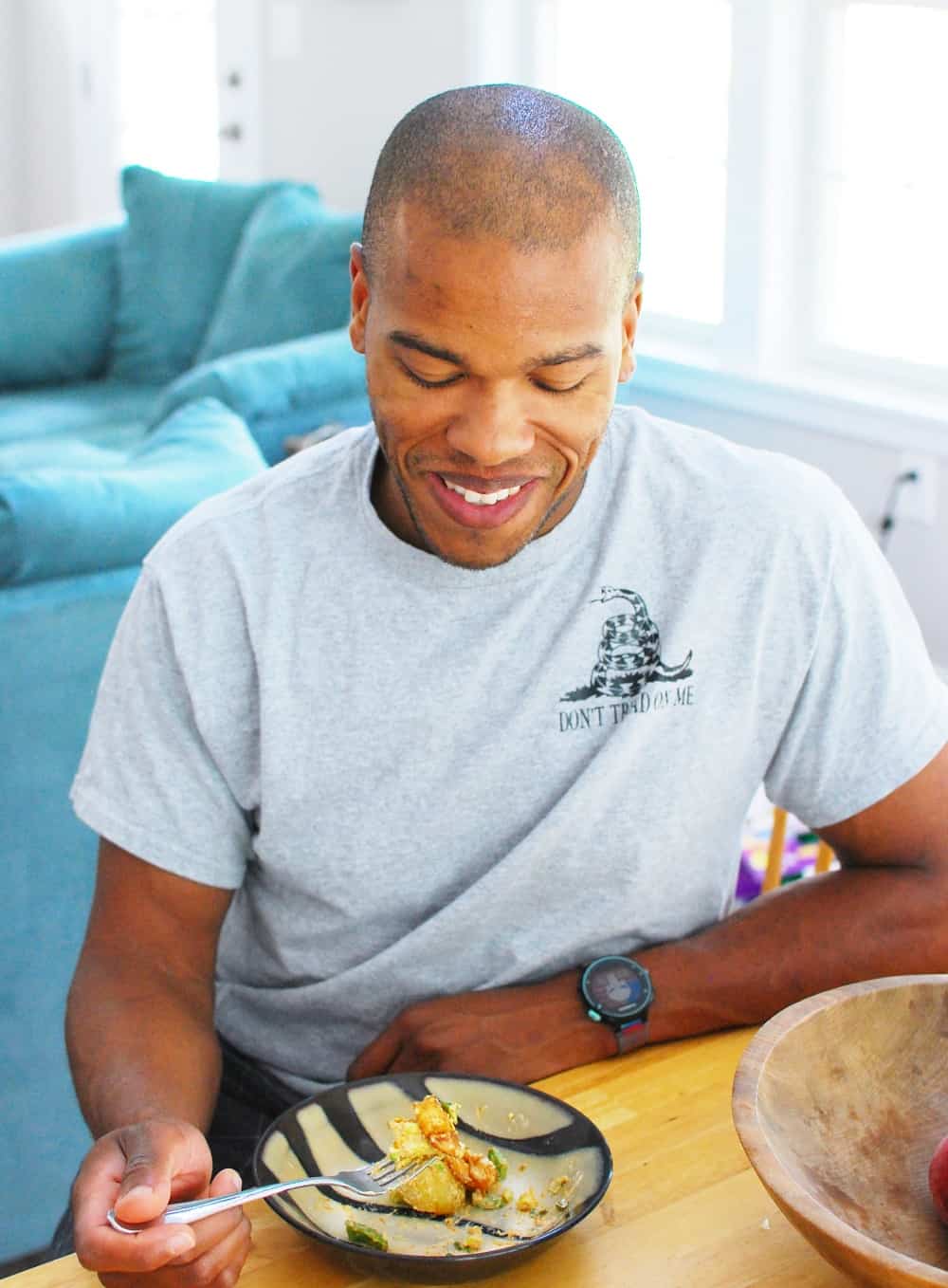 A man eating a bowl of healthy potato salad