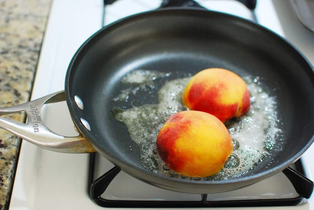 Cooking peaches in a skillet with butter