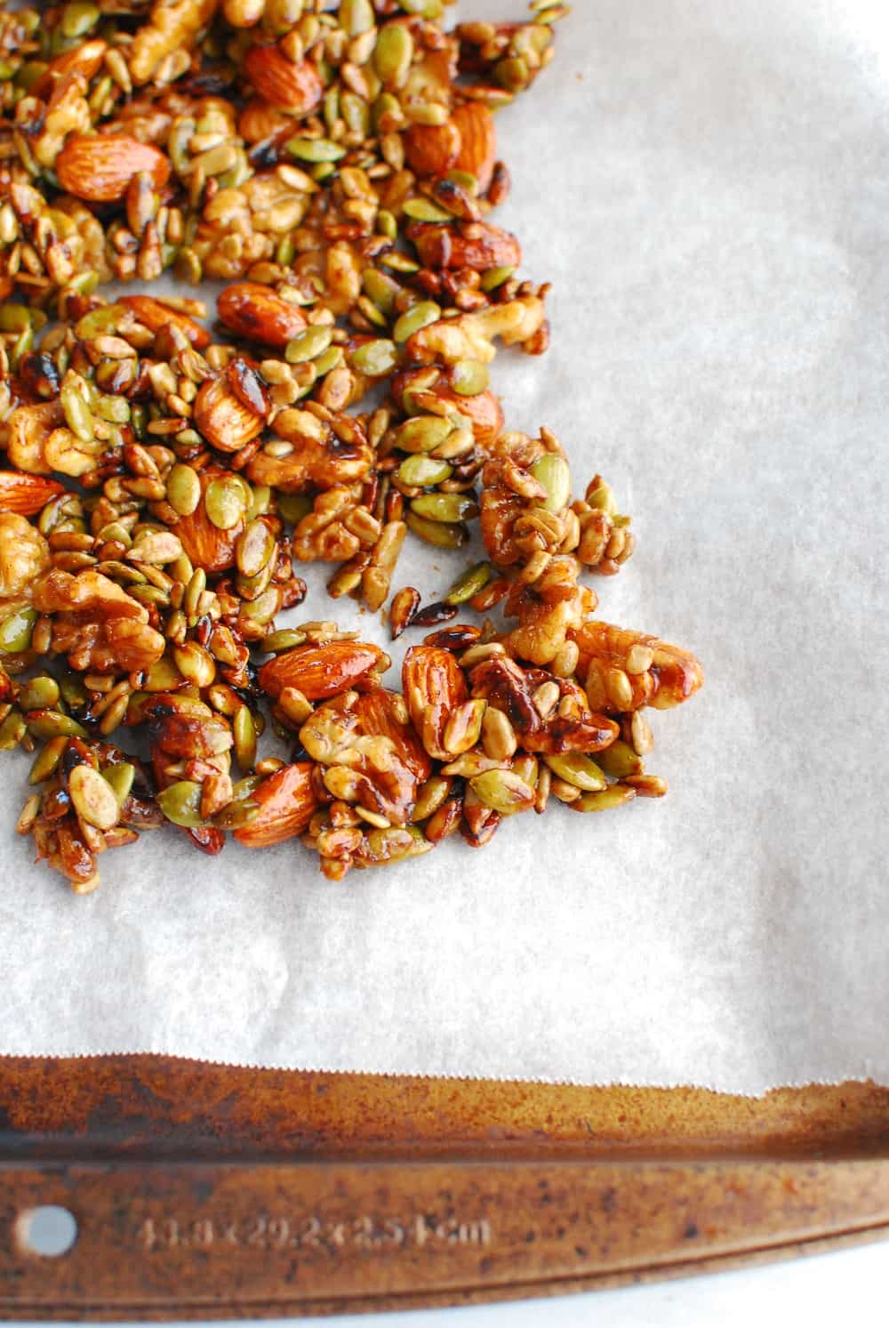 Maple glazed nuts and seeds drying on parchment paper