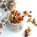 Fall trail mix in a jar next to a spoon of spilled trail mix