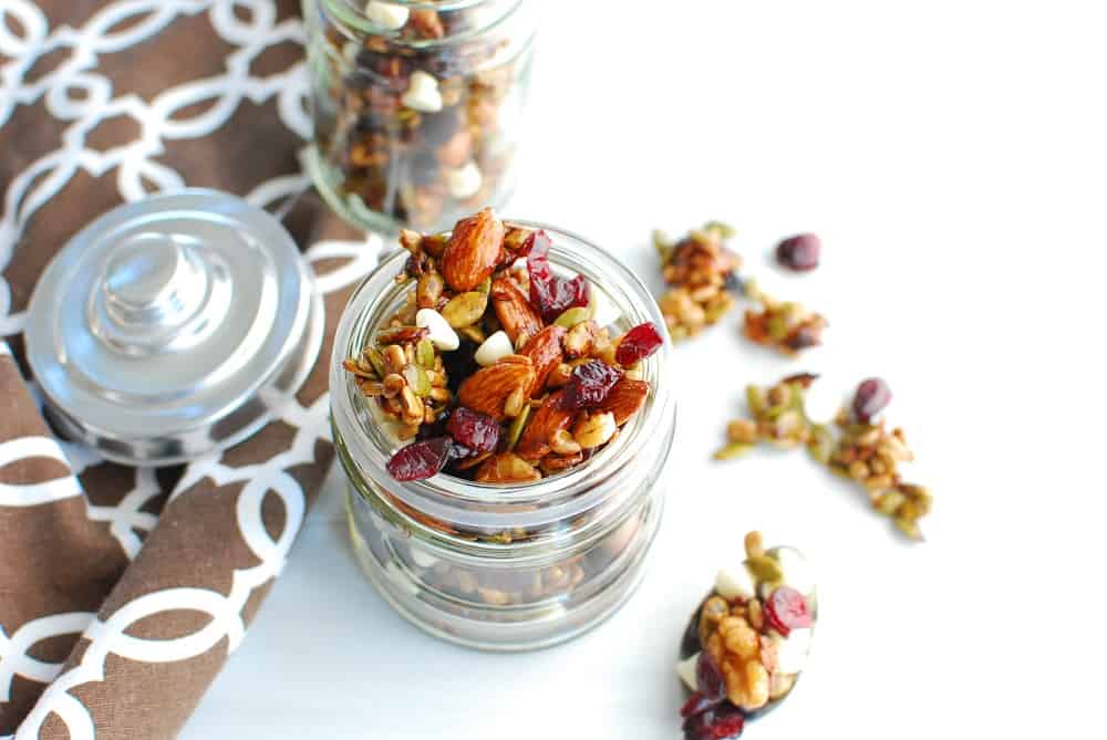 Fall trail mix in a glass jar next to a napkin.