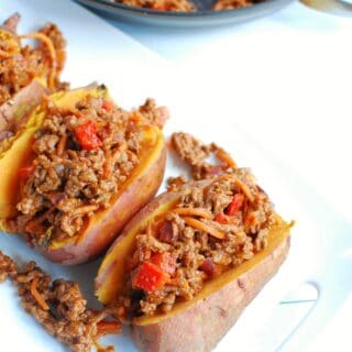 BBQ ground beef stuffed sweet potatoes on a white platter