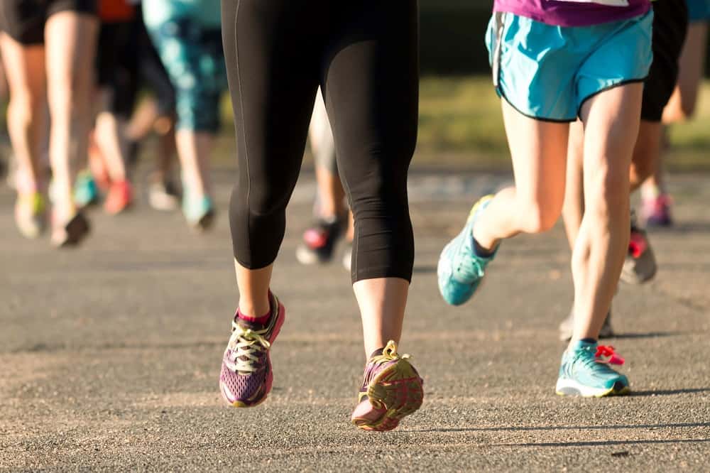 Several people's legs running a 5k race