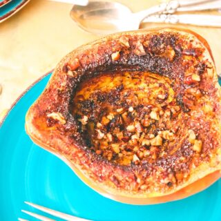 air fryer squash on a plate topped with sugar cinnamon and pecans