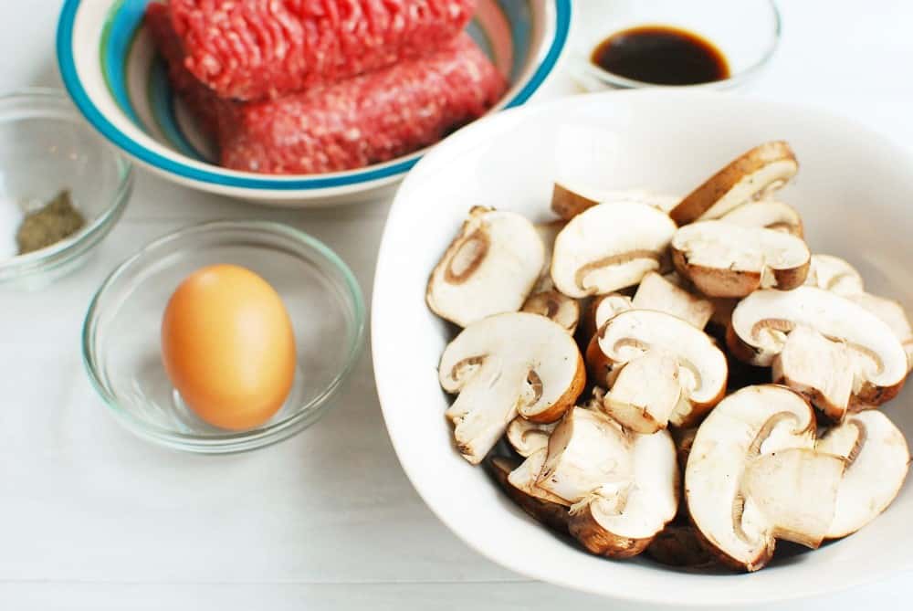 baby bella mushrooms in a bowl next to ground beef and an egg