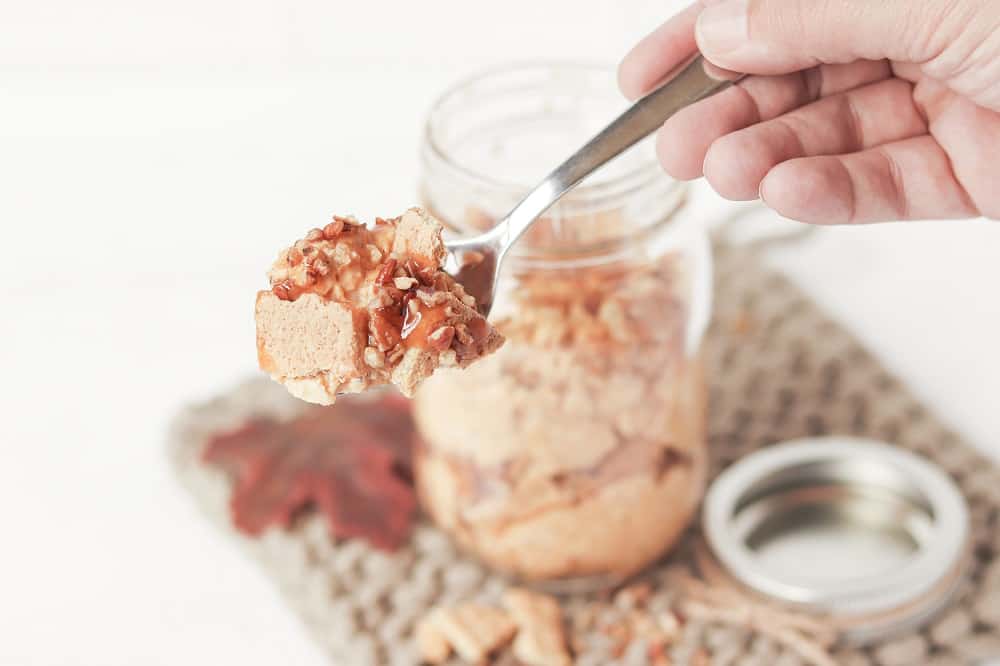 A woman's hand holding a spoonful of overnight oats