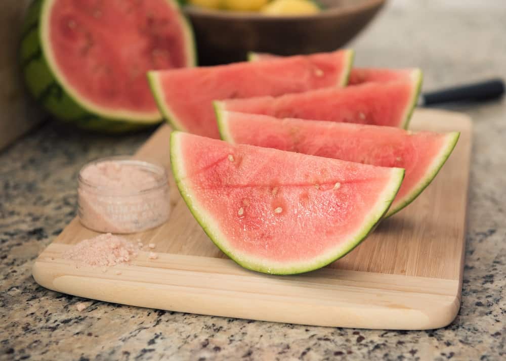 Several sliced pieces of watermelon on a cutting board