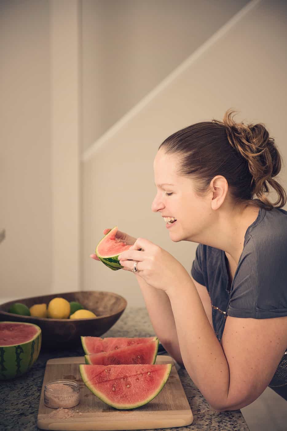 Eine Frau, die ein Stück Wassermelone genießt, ohne sich Gedanken darüber zu machen, ob es dick macht