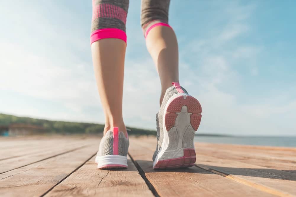 A close up of a a womans legs who is getting ready to run