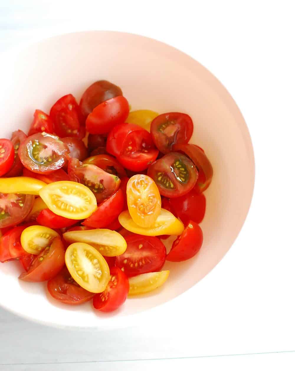 A bowl full of sliced cherry tomatoes