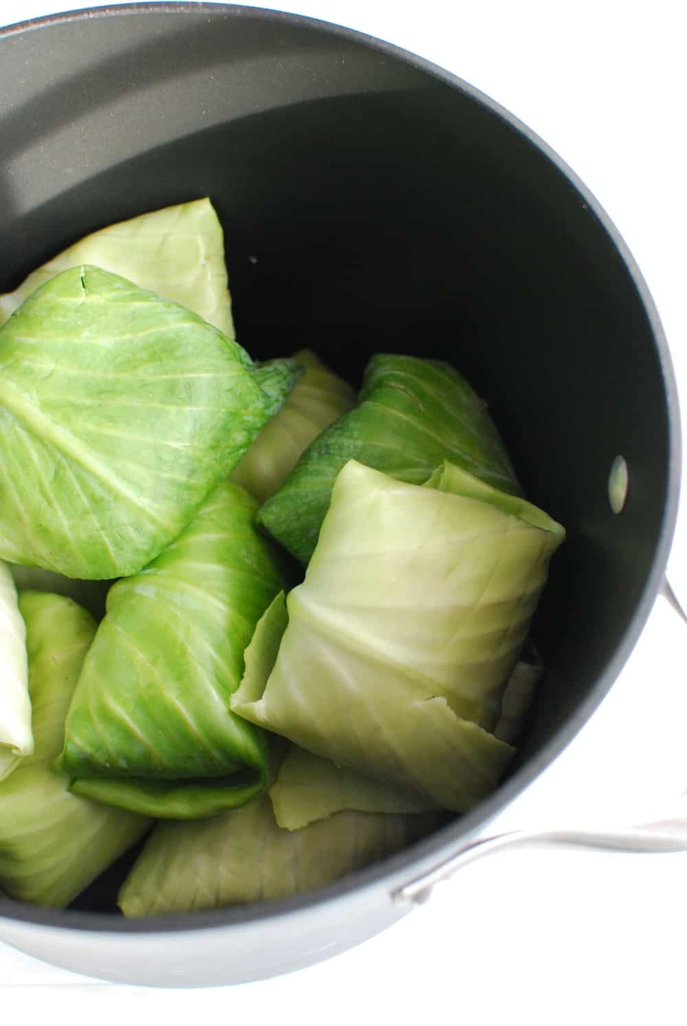 Stuffed cabbage rolls in a large pot before cooking