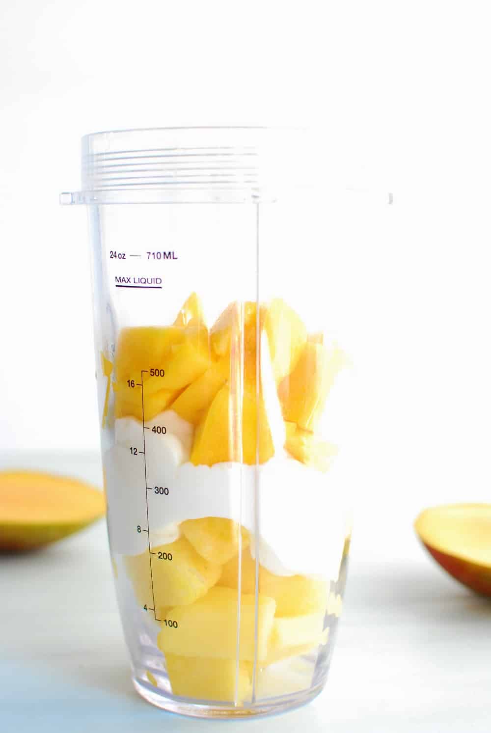 A blender cup filled with smoothie ingredients