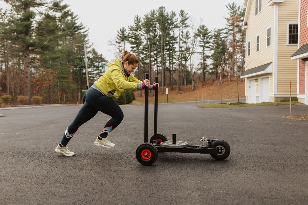 a woman using a weight sled 