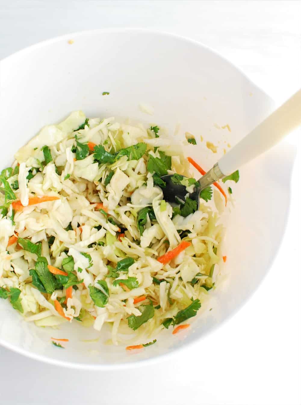 a white bowl full of cabbage slaw