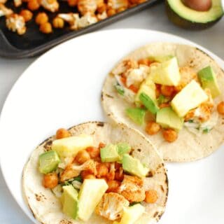 two vegan BBQ cauliflower tacos on a white plate