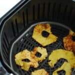 an air fryer basket with dehydrated pineapple