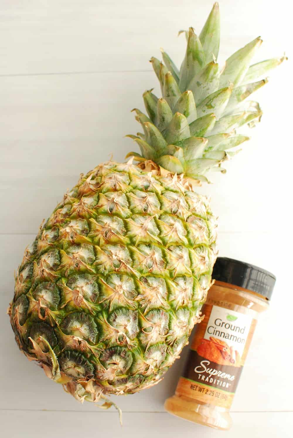 a whole pineapple and a bottle of cinnamon