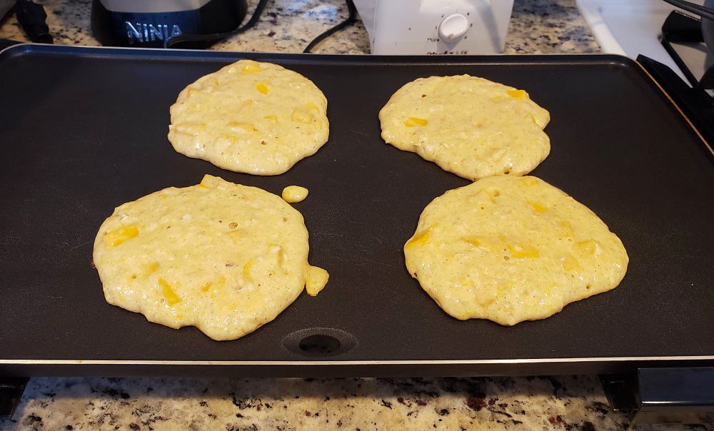 pancakes cooking on a griddle