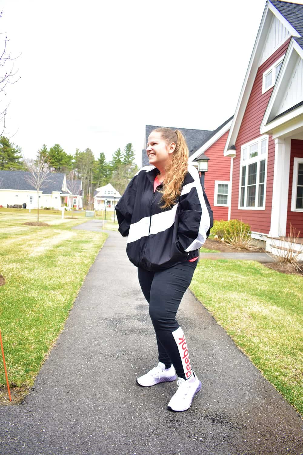 a woman getting ready to start a 30 day walking challenge outside in workout gear