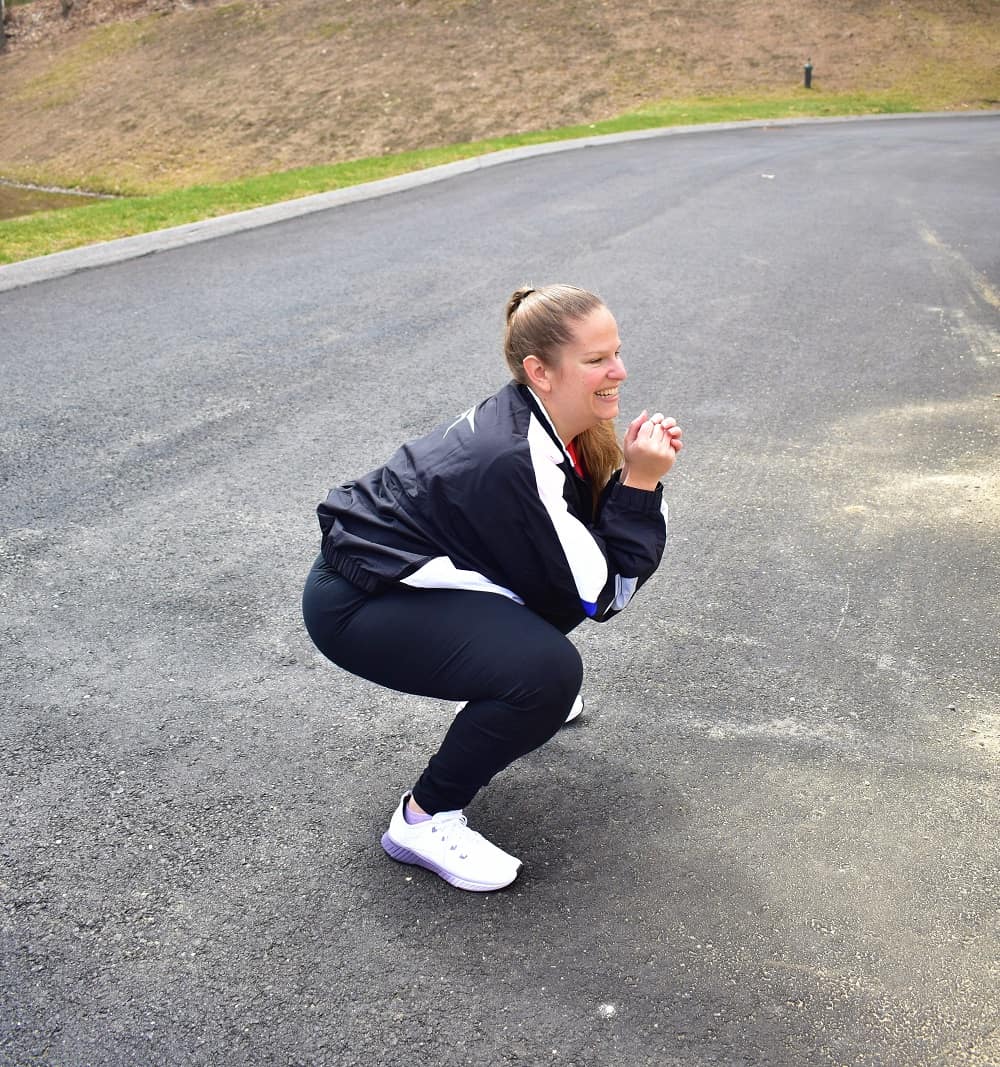 a woman doing squats outside