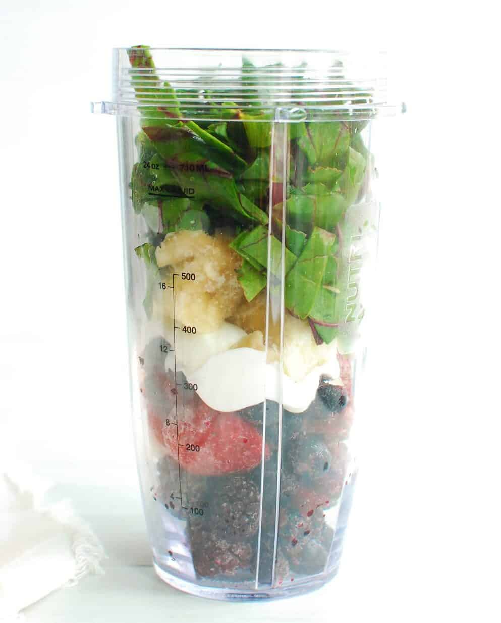 A blender cup full of ingredients to make a smoothie